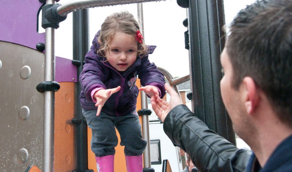 Parent helping child in playground