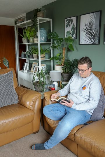 man sat reading book in home